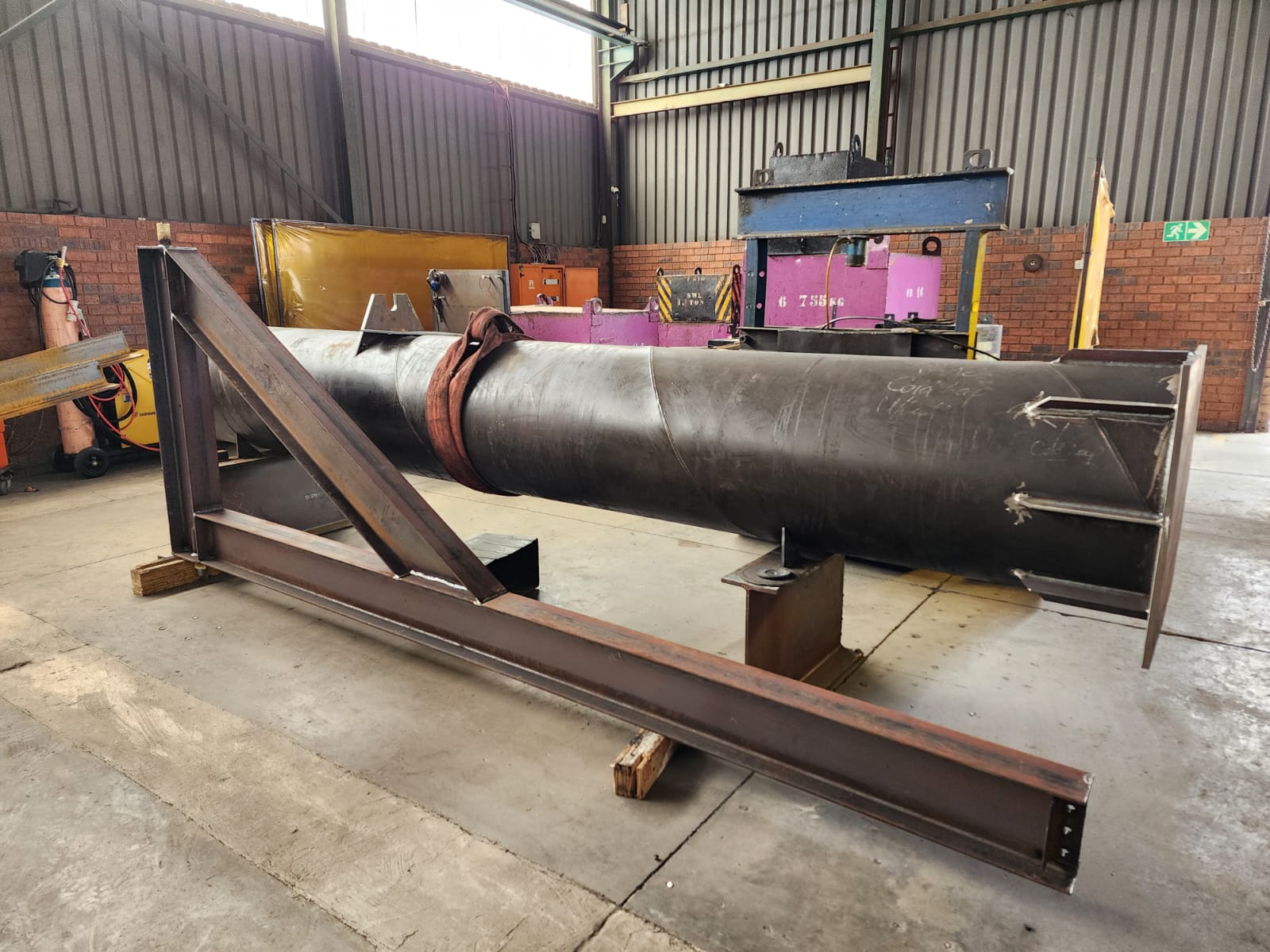 Cylindrical steel fabrication with bracing and a base structure.